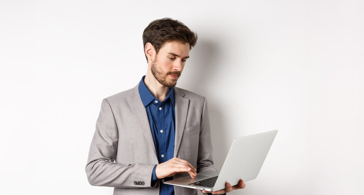 Profesionista con traje revisando información en su laptop